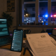 Blurred messaging screens and legal files inside a German apartment, illustrating a cross-border sexual assault investigation