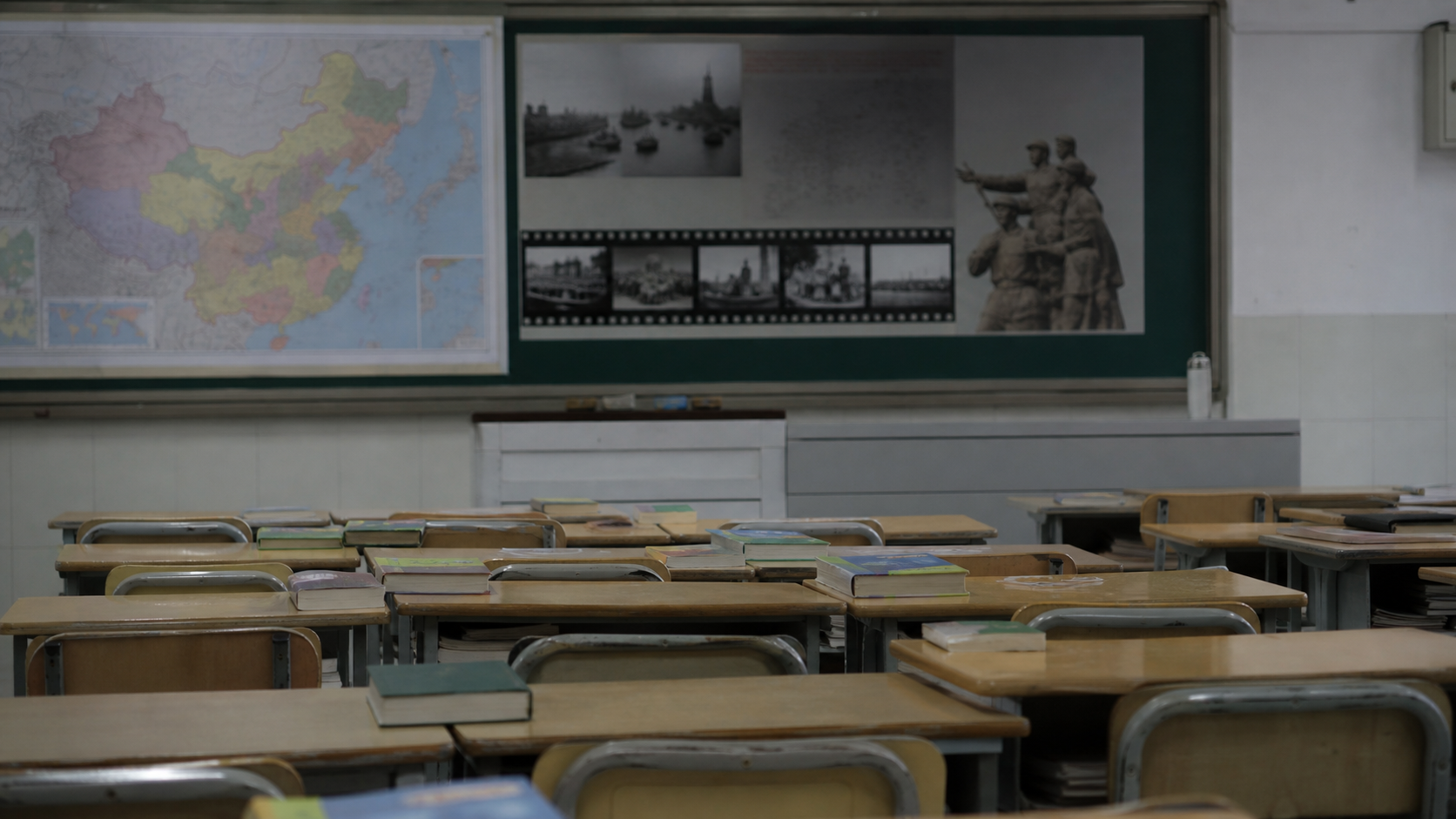 Realistic editorial image of an empty Chinese classroom with history materials about wartime memory and East Asia.