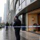Realistic editorial image of the aftermath outside a Japanese restaurant in Shanghai's financial district after a knife attack.
