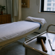A treatment room in an urban Chinese massage shop with a mallet and metal tool beside a therapy bed.