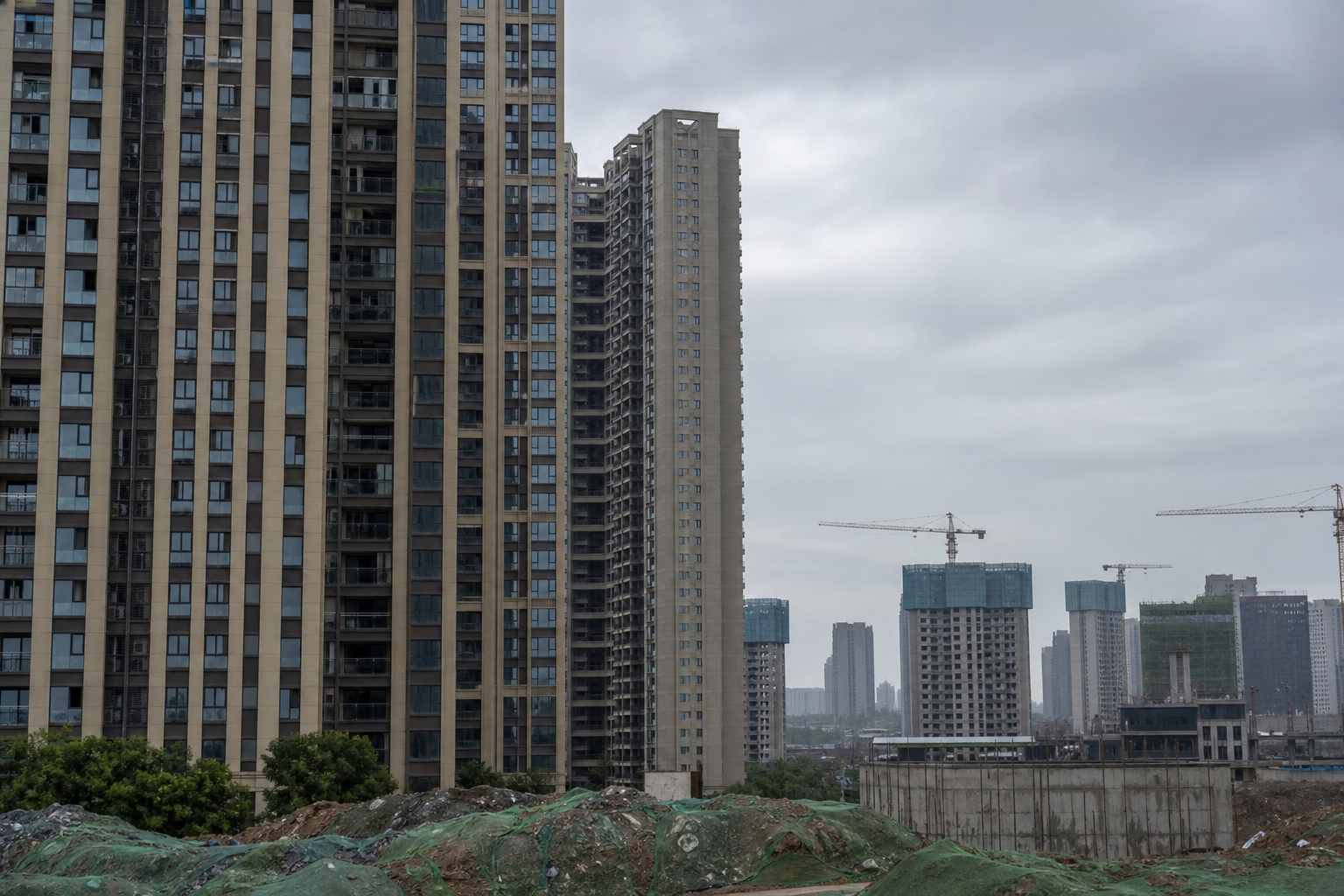 Chinese residential towers near cranes and unfinished construction.
