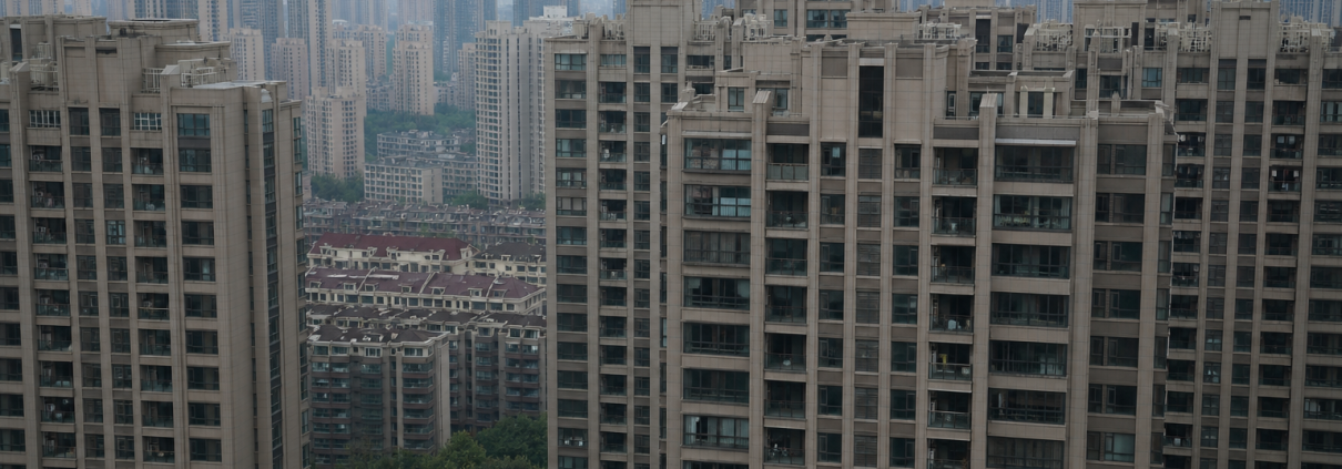 Residential high-rise apartment towers in a Chinese city under an overcast sky.