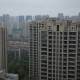 Residential high-rise apartment towers in a Chinese city under an overcast sky.