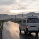 A small van traveling on a rural road in China during the early morning school commute.