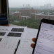 Printed biomedical research figures and a smartphone with a blurred Chinese short-video moderation notice on a desk